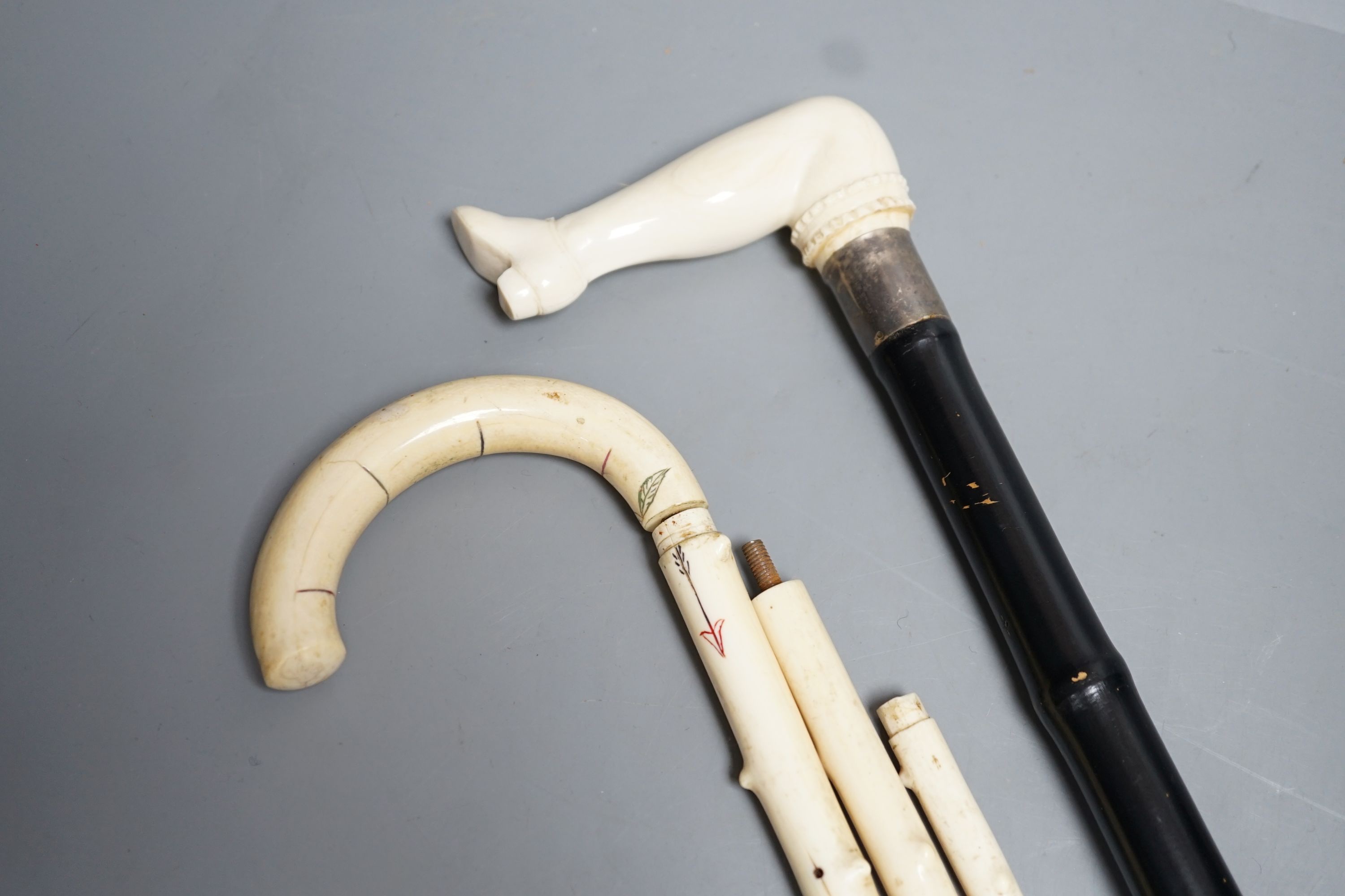 A silver mounted ivory handled ‘leg and shoe’ walking cane (88cm) and a sectional ivory walking cane, sections missing (a.f)